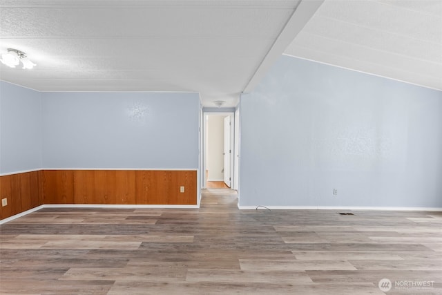 24709 148th Ave E, Graham, WA 98338 - unfurnished room with wood finished floors, wood walls, and wainscoting
