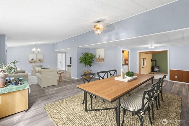 24709 148th Ave E, Graham, WA 98338 - dining space featuring a wood stove, wood finished floors, lofted ceiling, and a chandelier