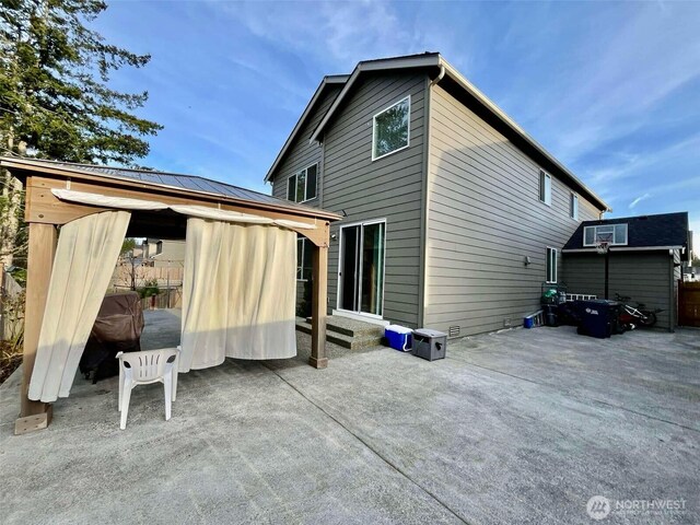 back of property with a gazebo and a patio area