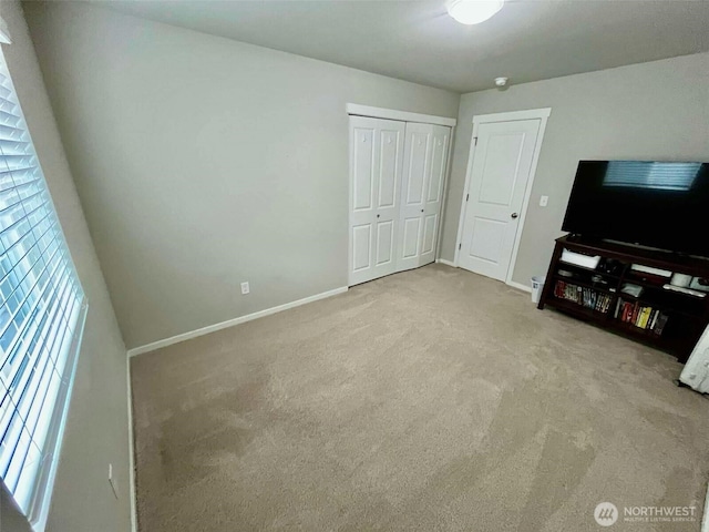 unfurnished living room featuring baseboards and carpet