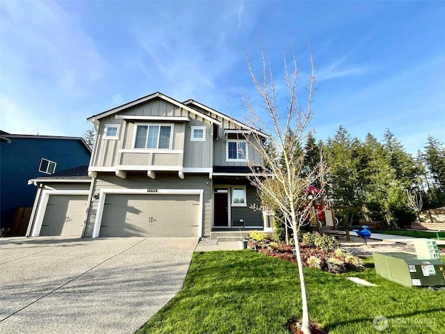 craftsman house with board and batten siding, a front yard, an attached garage, and concrete driveway