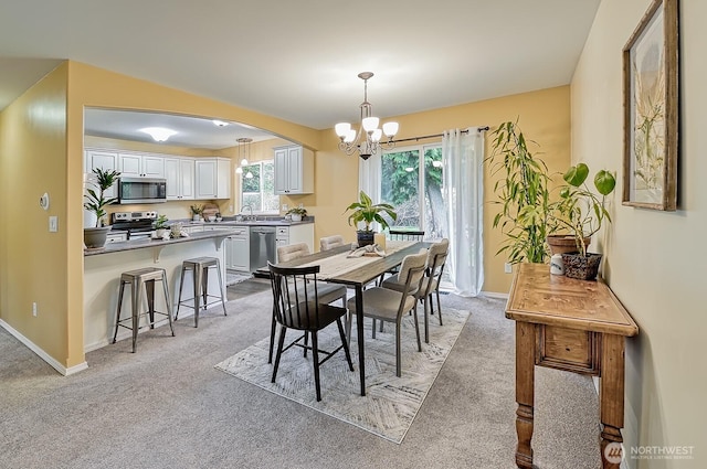 5786 Skagit Pl, Blaine, WA 98230 - dining area with arched walkways, a notable chandelier, light colored carpet, and baseboards