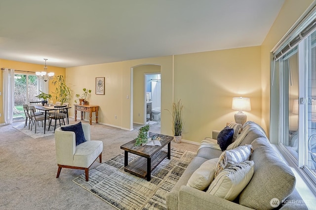 5786 Skagit Pl, Blaine, WA 98230 - living area with a chandelier, arched walkways, baseboards, and light carpet