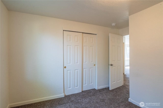 unfurnished bedroom with carpet flooring, a closet, and baseboards