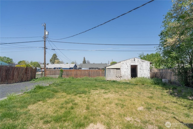 view of yard featuring an outdoor structure and fence