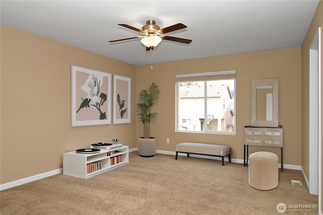 sitting room featuring carpet flooring, ceiling fan, visible vents, and baseboards