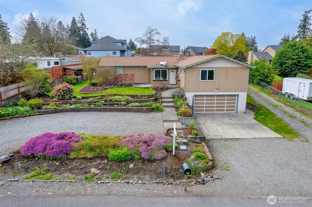 view of front facade featuring fence, a residential view, a garage, and concrete driveway