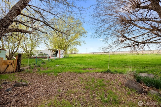 view of yard with a rural view and fence
