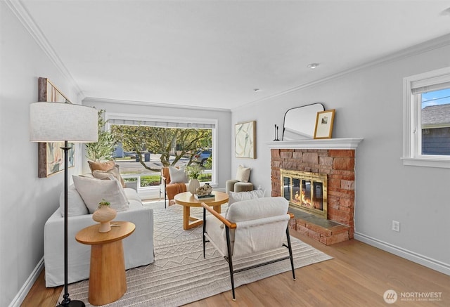 living room with baseboards, wood finished floors, a stone fireplace, and ornamental molding