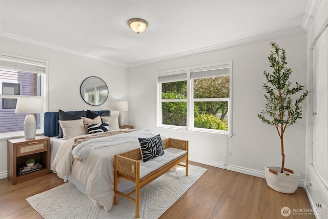 bedroom featuring baseboards, ornamental molding, and light wood-style floors