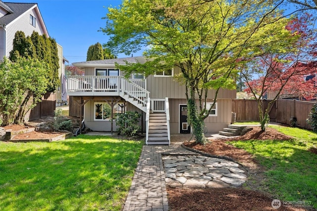 back of house with a wooden deck, a yard, a fenced backyard, and stairs