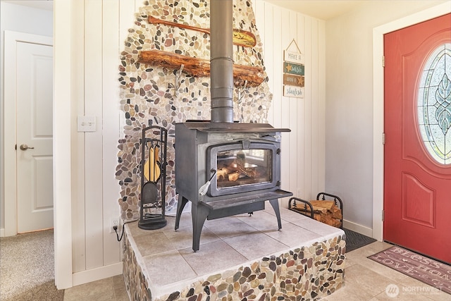 entrance foyer with baseboards and a wood stove