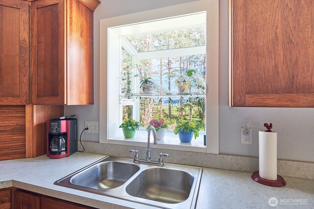 kitchen with brown cabinets, a sink, and light countertops