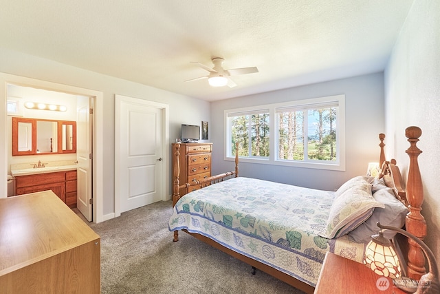 bedroom with a ceiling fan, light carpet, connected bathroom, a sink, and baseboards