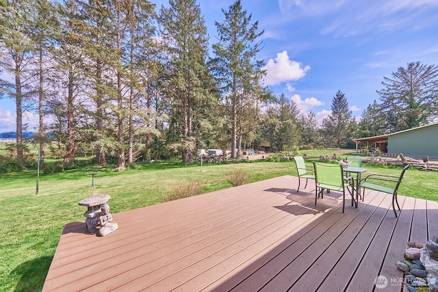 wooden terrace featuring a yard and outdoor dining space