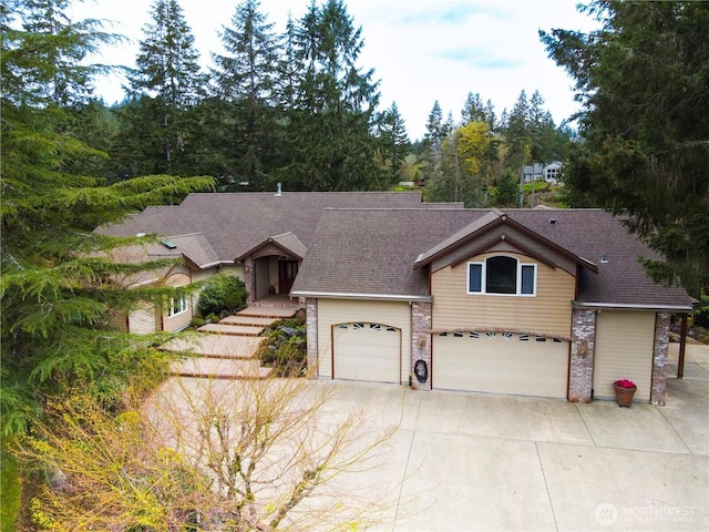 view of front of property with roof with shingles, driveway, and an attached garage