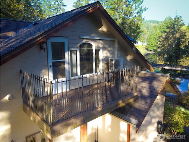 view of property exterior featuring roof with shingles and a balcony