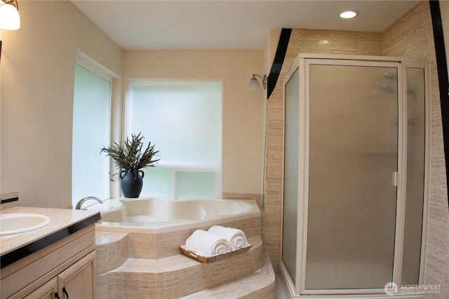 bathroom featuring a bath, vanity, and a stall shower