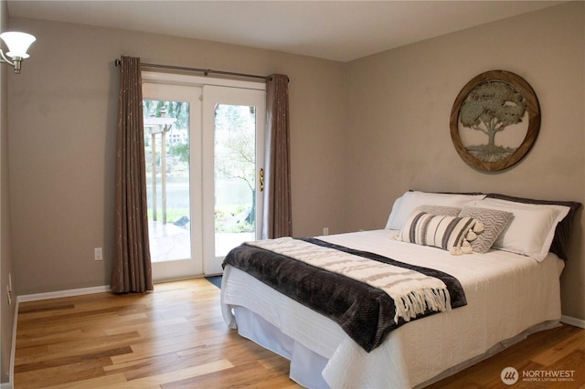 bedroom with multiple windows, access to outside, and light wood finished floors