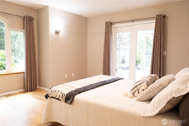 bedroom featuring visible vents, access to exterior, baseboards, and light wood-style floors
