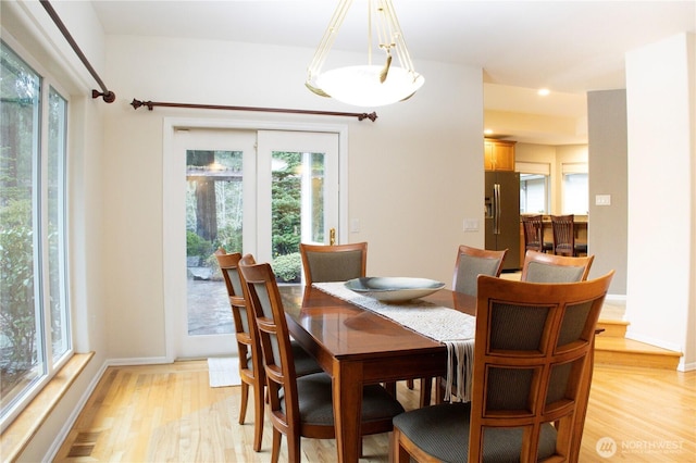 dining room with light wood-style floors, baseboards, and visible vents