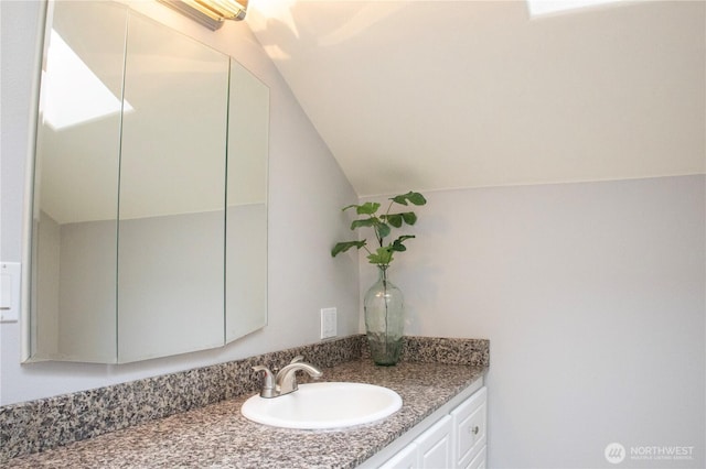 bathroom with vanity and vaulted ceiling