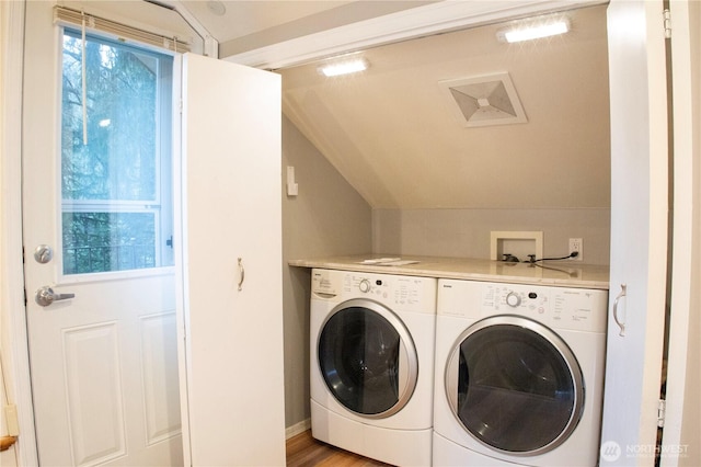 laundry room with washer and clothes dryer, light wood-style floors, and laundry area