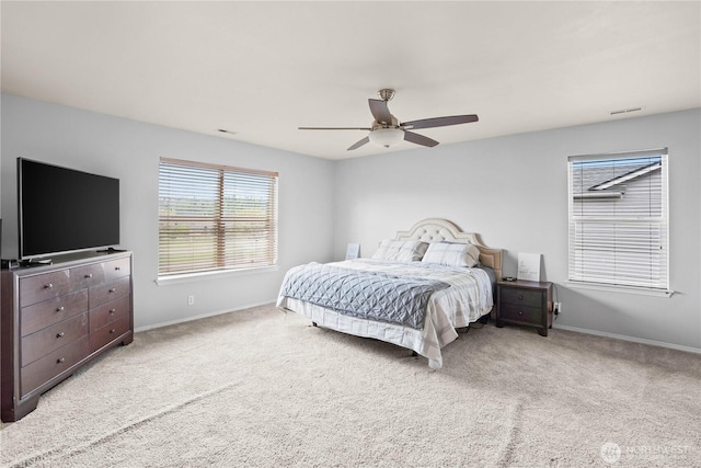 carpeted bedroom with a ceiling fan, baseboards, and visible vents