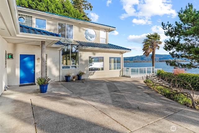 1192 E State Route 4, Cathlamet, WA 98612 - doorway to property with stucco siding, a mountain view, a patio area, and a tiled roof