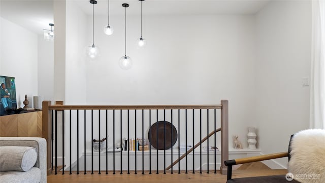 sitting room featuring an upstairs landing and wood finished floors