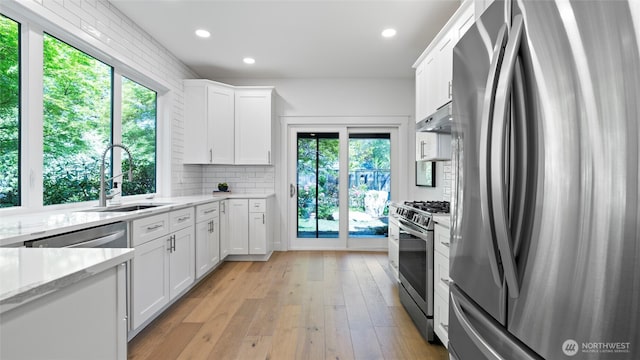 kitchen with white cabinets, a sink, stainless steel appliances, recessed lighting, and under cabinet range hood