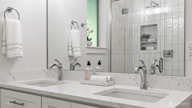 full bath with a sink, a stall shower, and double vanity