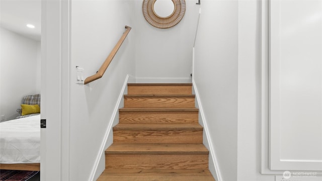 stairway featuring baseboards, recessed lighting, and wood finished floors