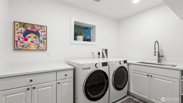 washroom with separate washer and dryer, a sink, cabinet space, and recessed lighting