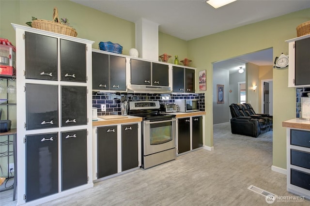 kitchen with light wood-style flooring, under cabinet range hood, light countertops, stainless steel appliances, and backsplash