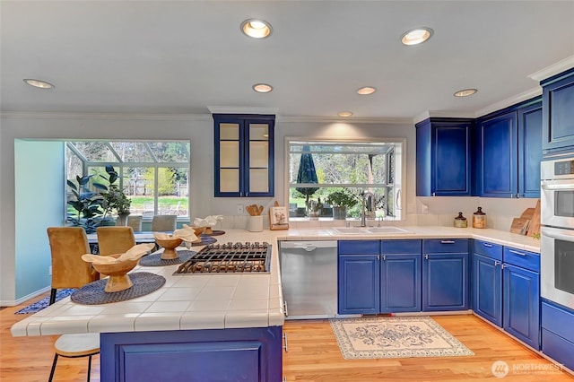 26225 Lake Wilderness Country Club Dr SE, Maple Valley, WA 98038 - kitchen featuring stainless steel appliances, tile countertops, a sink, a wealth of natural light, and crown molding