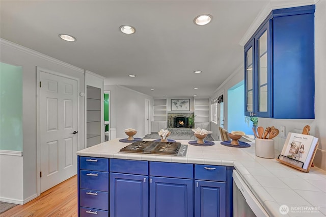 26225 Lake Wilderness Country Club Dr SE, Maple Valley, WA 98038 - kitchen with recessed lighting, a warm lit fireplace, light wood-style floors, glass insert cabinets, and open floor plan