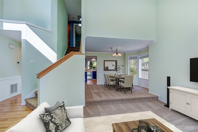 26225 Lake Wilderness Country Club Dr SE, Maple Valley, WA 98038 - living room featuring baseboards, visible vents, a chandelier, a high ceiling, and stairs
