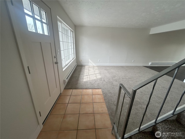carpeted entryway featuring a textured ceiling, a baseboard heating unit, a healthy amount of sunlight, and a baseboard radiator
