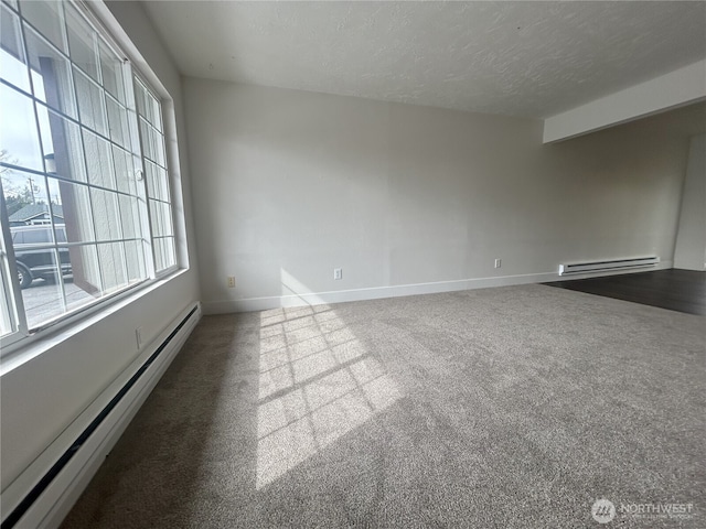 spare room with carpet, baseboards, baseboard heating, and a textured ceiling