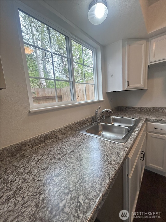 kitchen featuring a sink, white cabinetry, and dark countertops