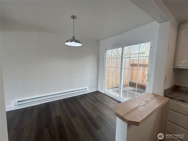 unfurnished dining area with baseboards, a baseboard radiator, and dark wood-type flooring