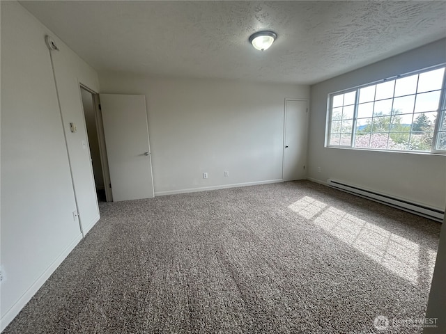 empty room with baseboards, a baseboard radiator, carpet, and a textured ceiling