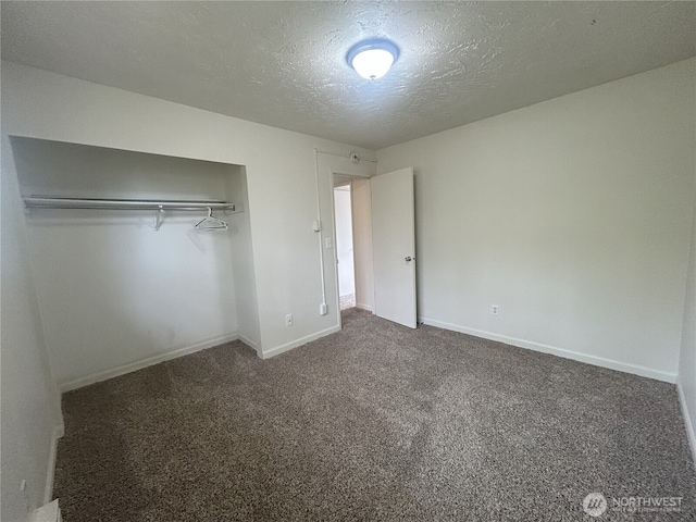 unfurnished bedroom with baseboards, a textured ceiling, carpet, and a closet