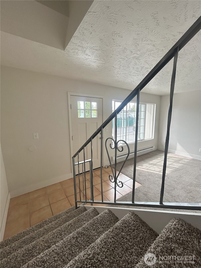 stairway featuring a textured ceiling, tile patterned floors, baseboards, and a baseboard radiator