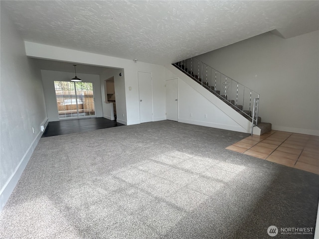 unfurnished living room featuring a textured ceiling, carpet, baseboards, and stairway