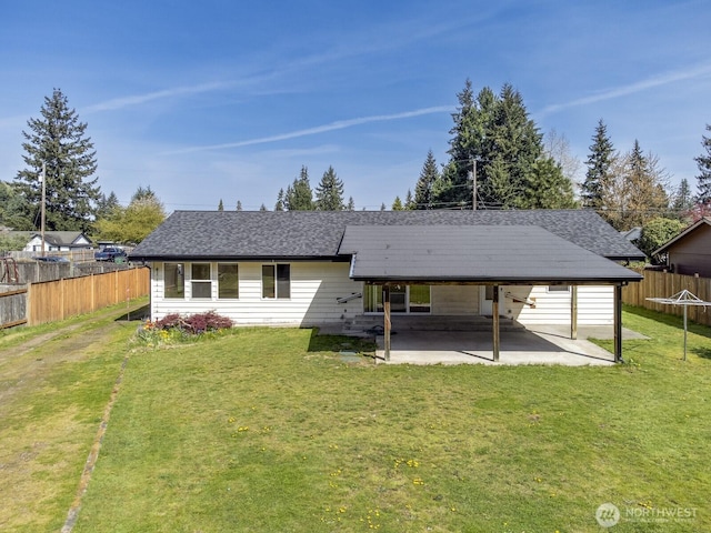 rear view of house with a patio, a carport, a yard, and fence