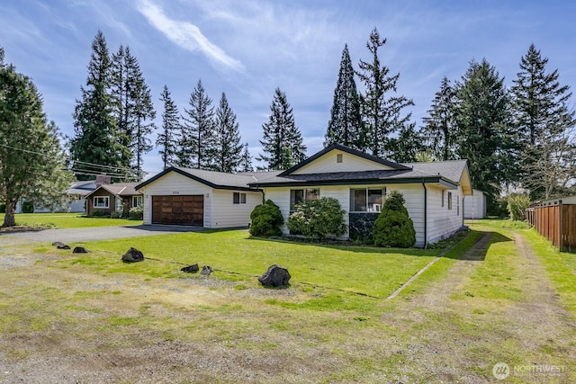 view of front facade featuring fence, a front yard, and aphalt driveway