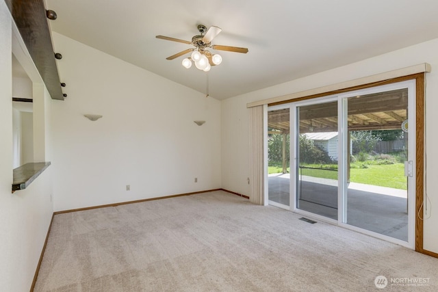 spare room featuring lofted ceiling, carpet flooring, visible vents, ceiling fan, and baseboards