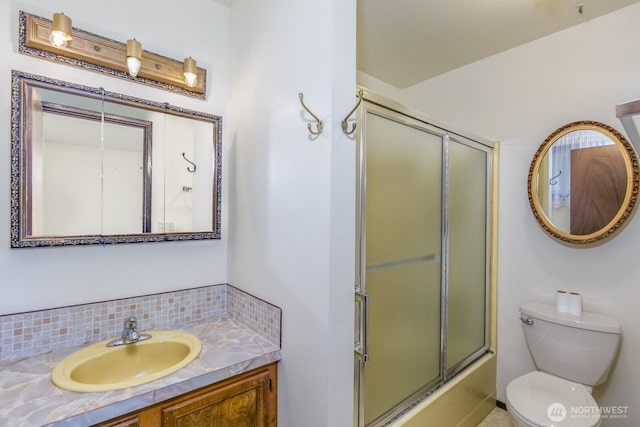 full bathroom featuring tasteful backsplash, vanity, toilet, and combined bath / shower with glass door